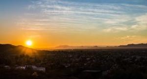 A scenic photo of the sun setting within Phoenix, Arizona.