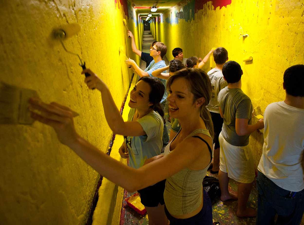 澳门威尼斯人网上赌场的学生们在隧道的涂鸦墙上作画
